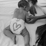 Newborn wearing a Rebelalike diaper with heart print, black and white