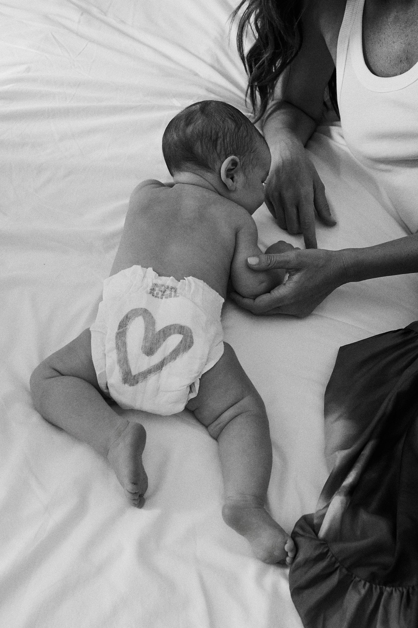 Newborn wearing a Rebelalike diaper with heart print, black and white