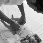 Dad changing a newborn into a Rebelalike diaper, black and white
