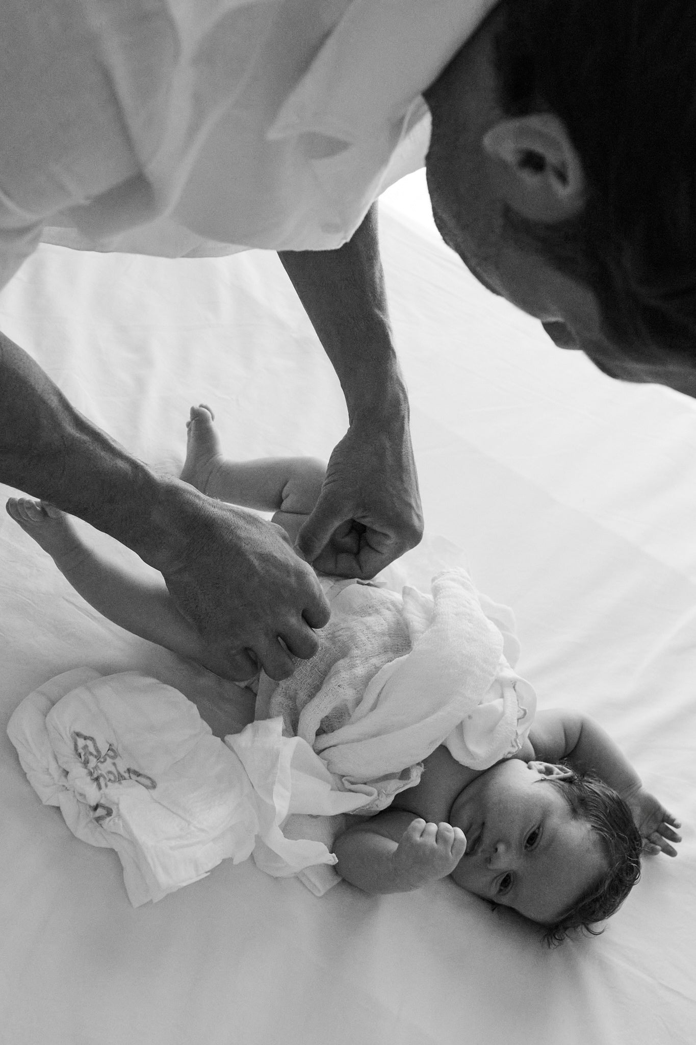 Dad changing a newborn into a Rebelalike diaper, black and white