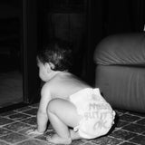 Baby crawling in a Rebelalike diaper with Messy But It's OK print, black and white