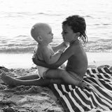 Baby and big brother on the beach in Ibiza, black and white