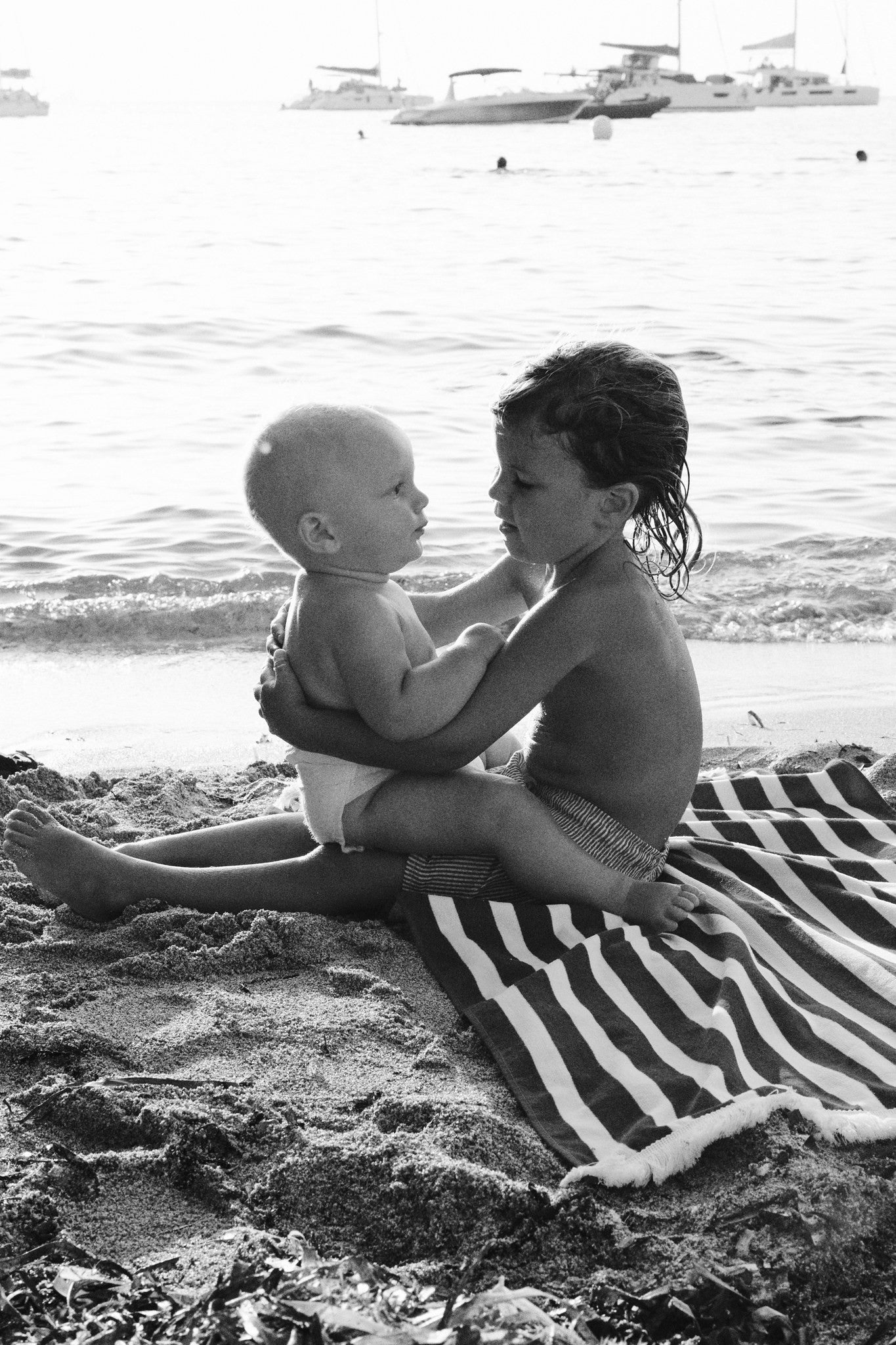 Baby and big brother on the beach in Ibiza, black and white