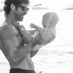 Dad holding his baby in a Rebelalike diaper at sunset, black and white