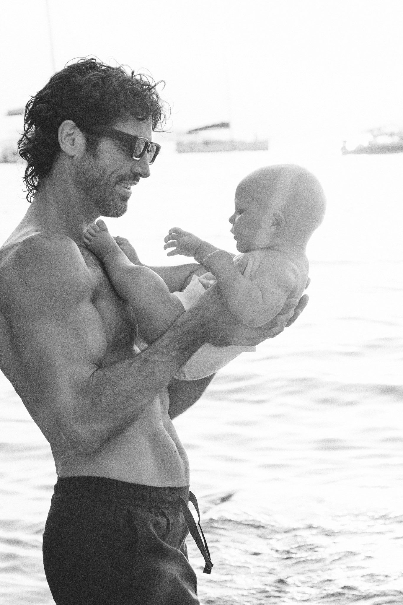 Dad holding his baby in a Rebelalike diaper at sunset, black and white