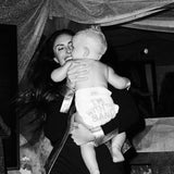 Mom holding her baby in a Rebelalike diaper with I'm With The Band print, black and white