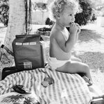Toddler in a Rebelalike diaper with a pack of Rebelalike diapers under a tree, black and white