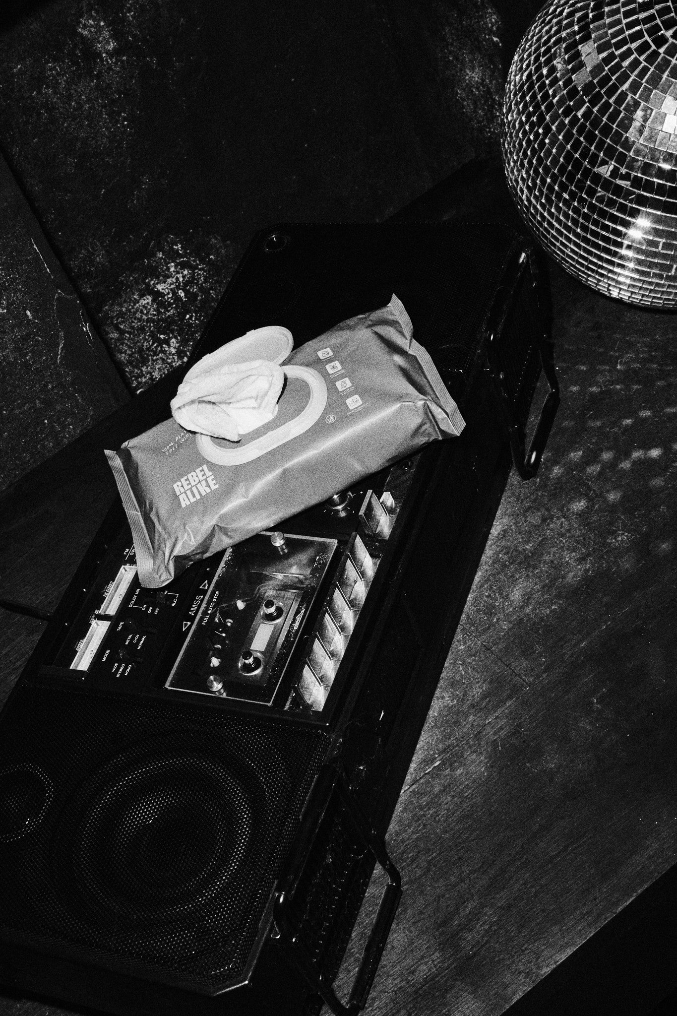 Rebelalike baby wipes on a boombox next to a disco ball, black and white